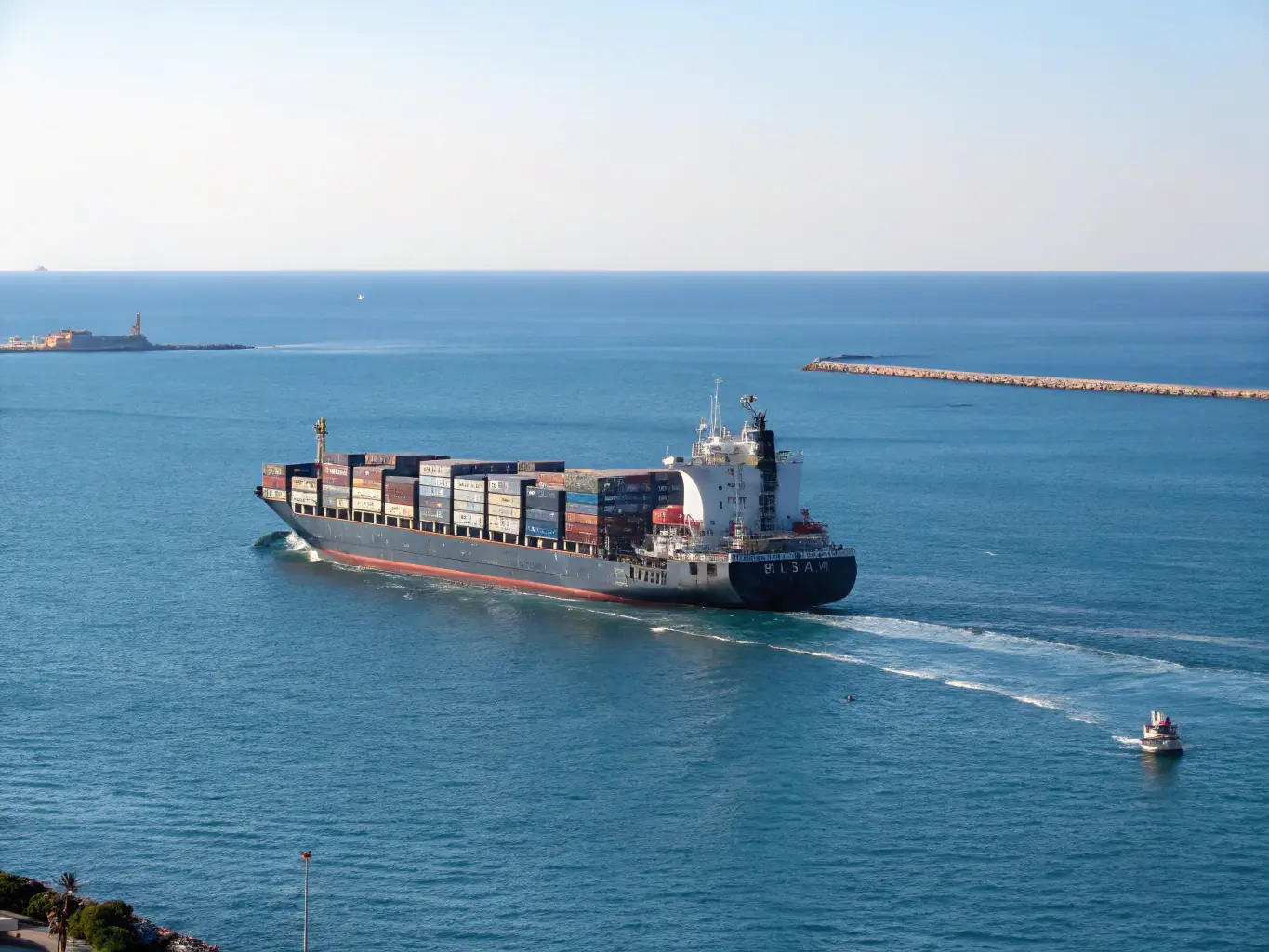 A modern cargo ship sailing on a calm sea at sunset, containers visible on deck, symbolizing global freight forwarding services offered by Exim Americas.